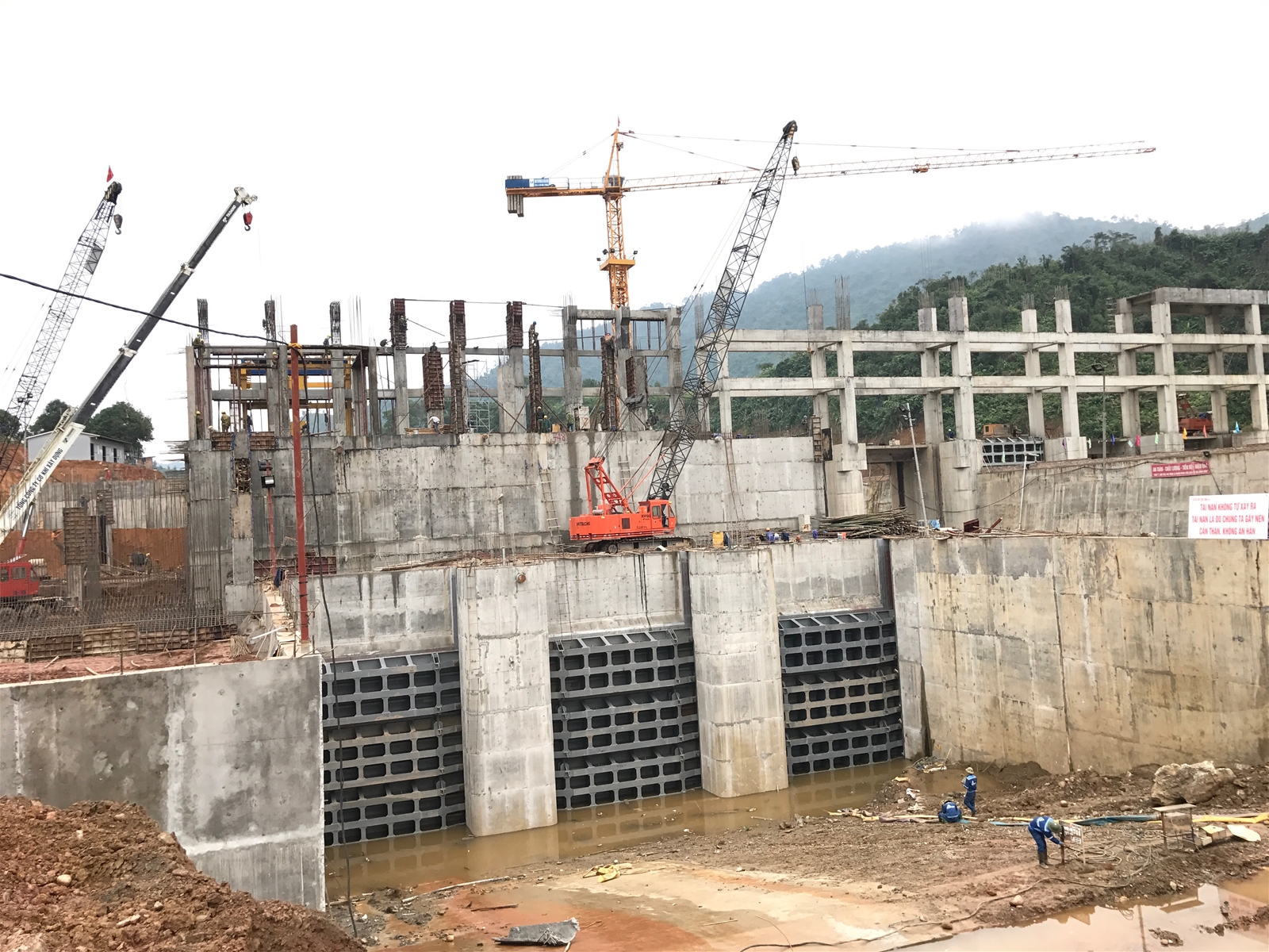Các công nhân đang thi công phần mặt đập chắn nước.